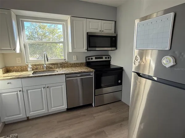 a kitchen with a refrigerator sink and window