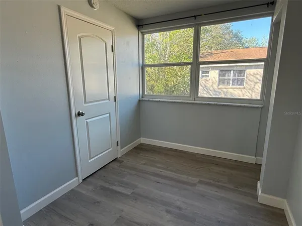 an empty room with wooden floor and a window