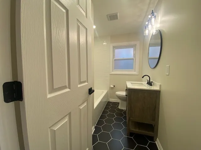 a spacious bathroom with a mirror a sink and a mirror