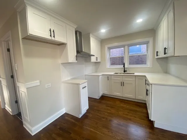 a kitchen with a sink cabinets stainless steel appliances and a window