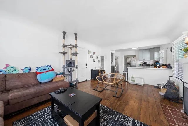 a living room with furniture and a dining table with kitchen view