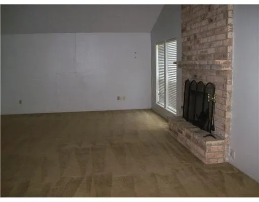 a view of a livingroom with wooden floor and a fireplace