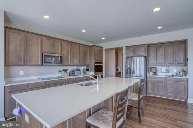 a kitchen with kitchen island a wooden floor and white cabinets