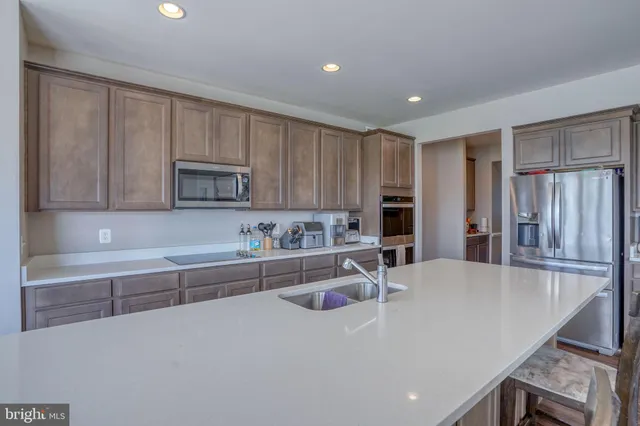 a kitchen with kitchen island a sink stove and microwave