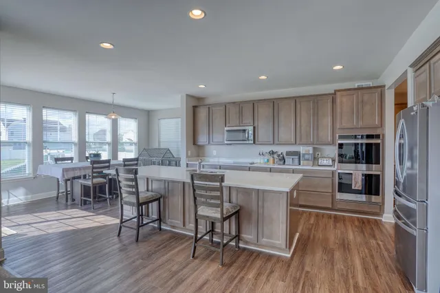 a kitchen with a table chairs refrigerator microwave and cabinets