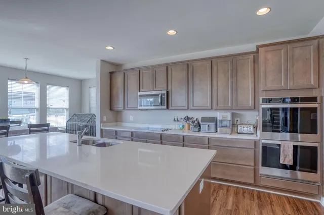 a kitchen with stainless steel appliances granite countertop a sink a stove and cabinets