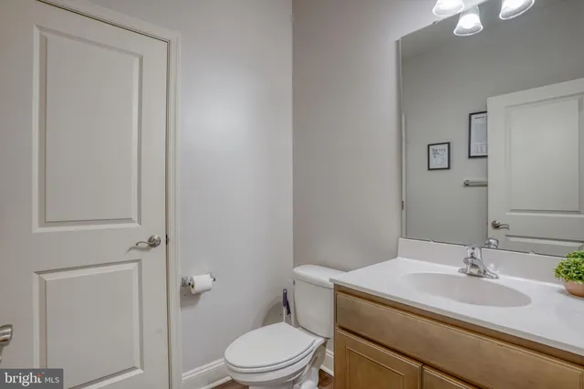a bathroom with a granite countertop sink toilet a mirror and shower
