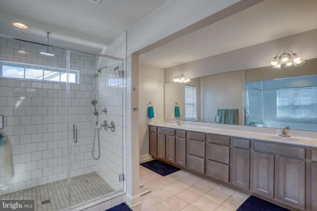 a bathroom with a double vanity sink mirror and shower