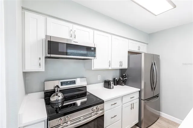 a kitchen with stainless steel appliances a stove a microwave and a refrigerator