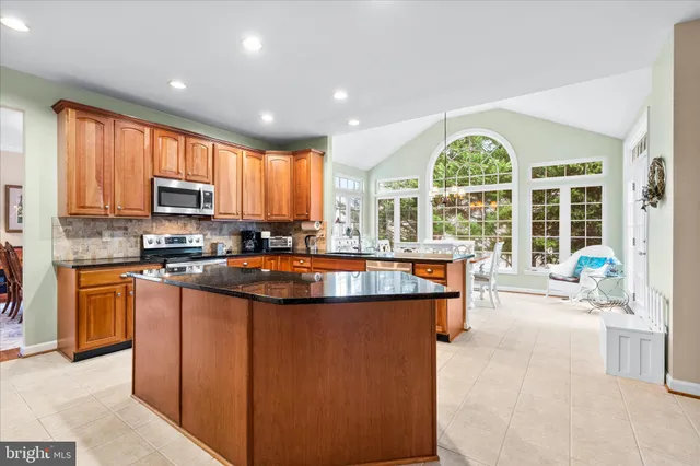a kitchen with stainless steel appliances granite countertop a stove a sink a refrigerator and a microwave