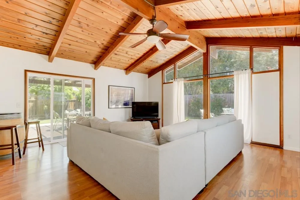 4925 Rebel Road San Diego, CA 92117 - Photo 5 of 25 a living room with furniture a wooden floor and a floor to ceiling window