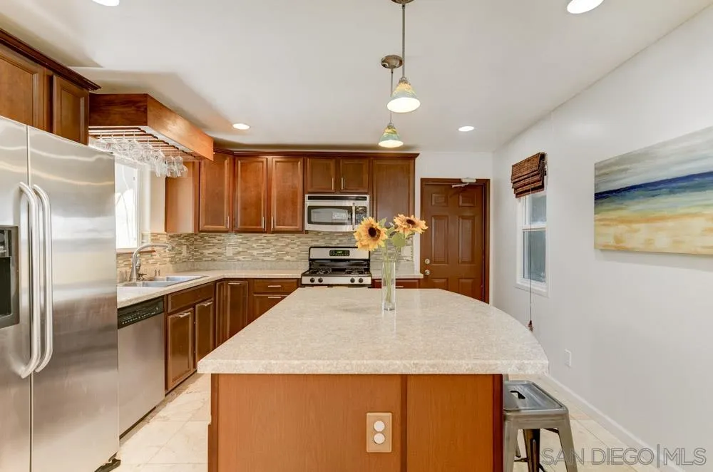 4925 Rebel Road San Diego, CA 92117 - Photo 8 of 25 a kitchen with a refrigerator a sink a stove and cabinets