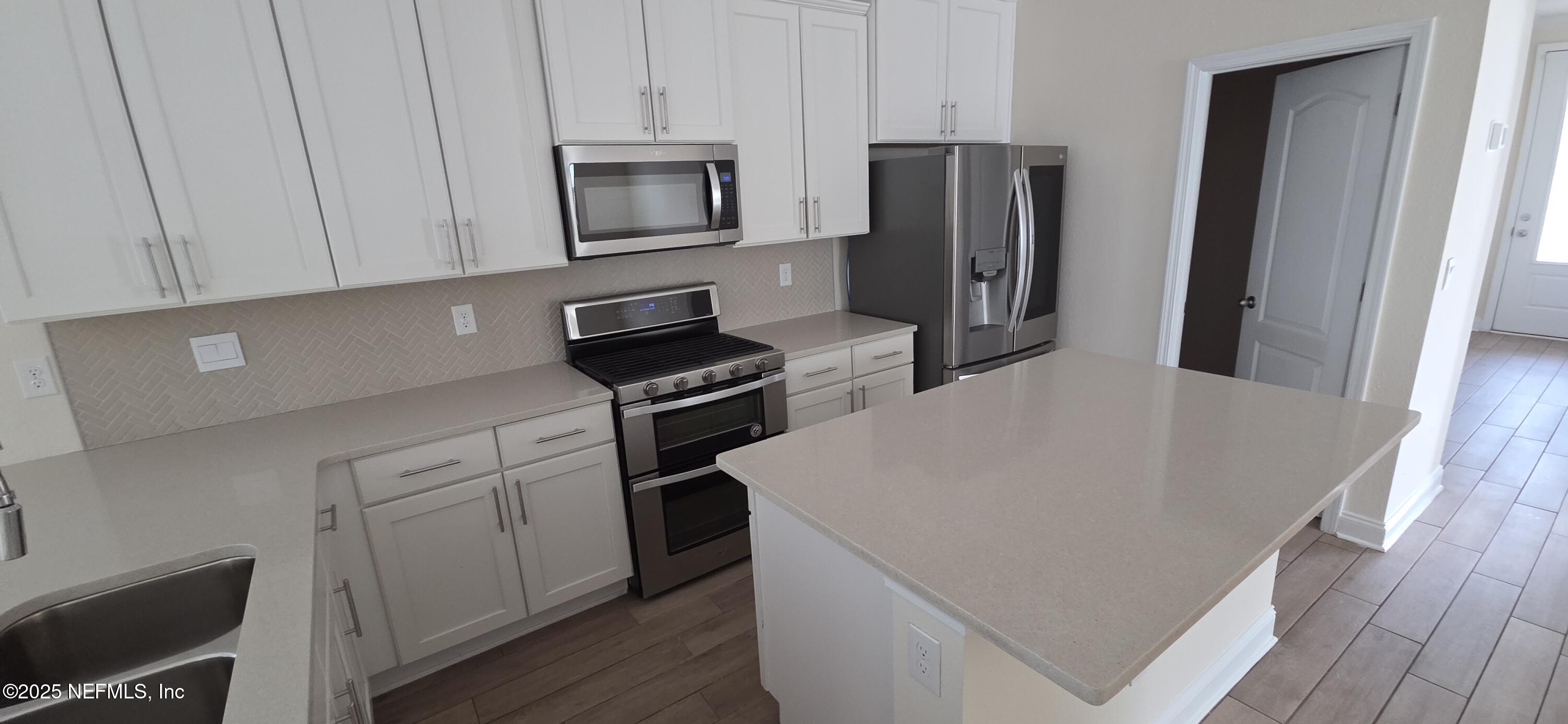 228 Thistleton Way Street St. Augustine, FL 32092 - Photo 15 of 25 a kitchen with stainless steel appliances a refrigerator microwave and sink
