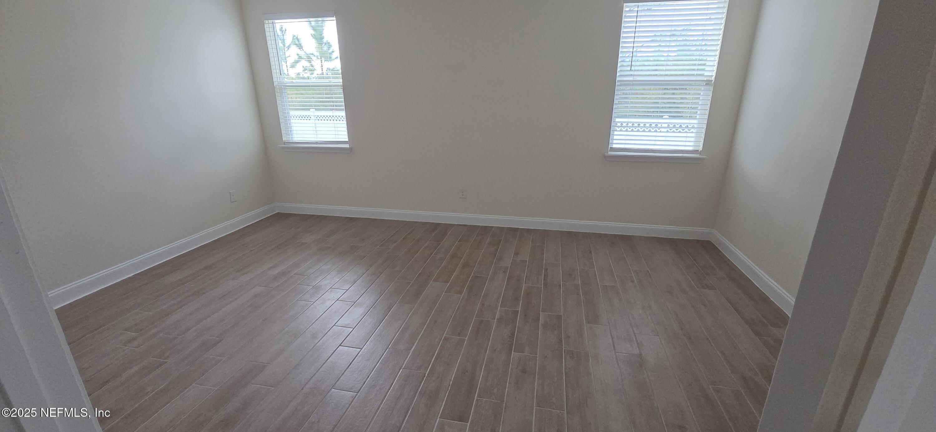 228 Thistleton Way Street St. Augustine, FL 32092 - Photo 16 of 25 an empty room with wooden floor and windows