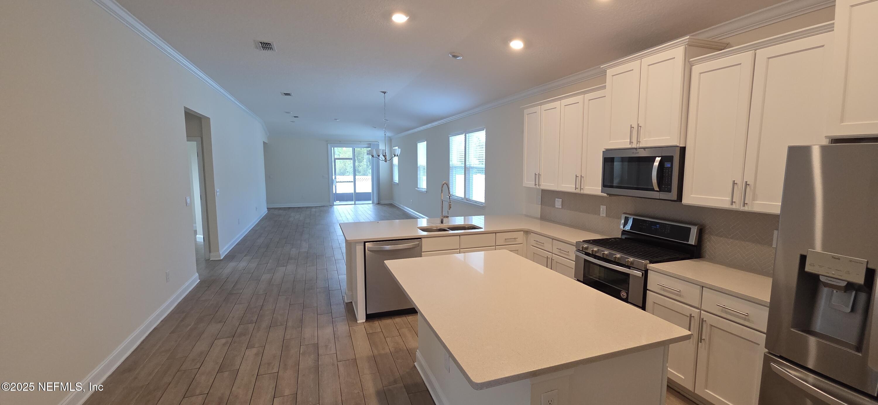 228 Thistleton Way Street St. Augustine, FL 32092 - Photo 3 of 15 a large kitchen with a large counter top stainless steel appliances and cabinets