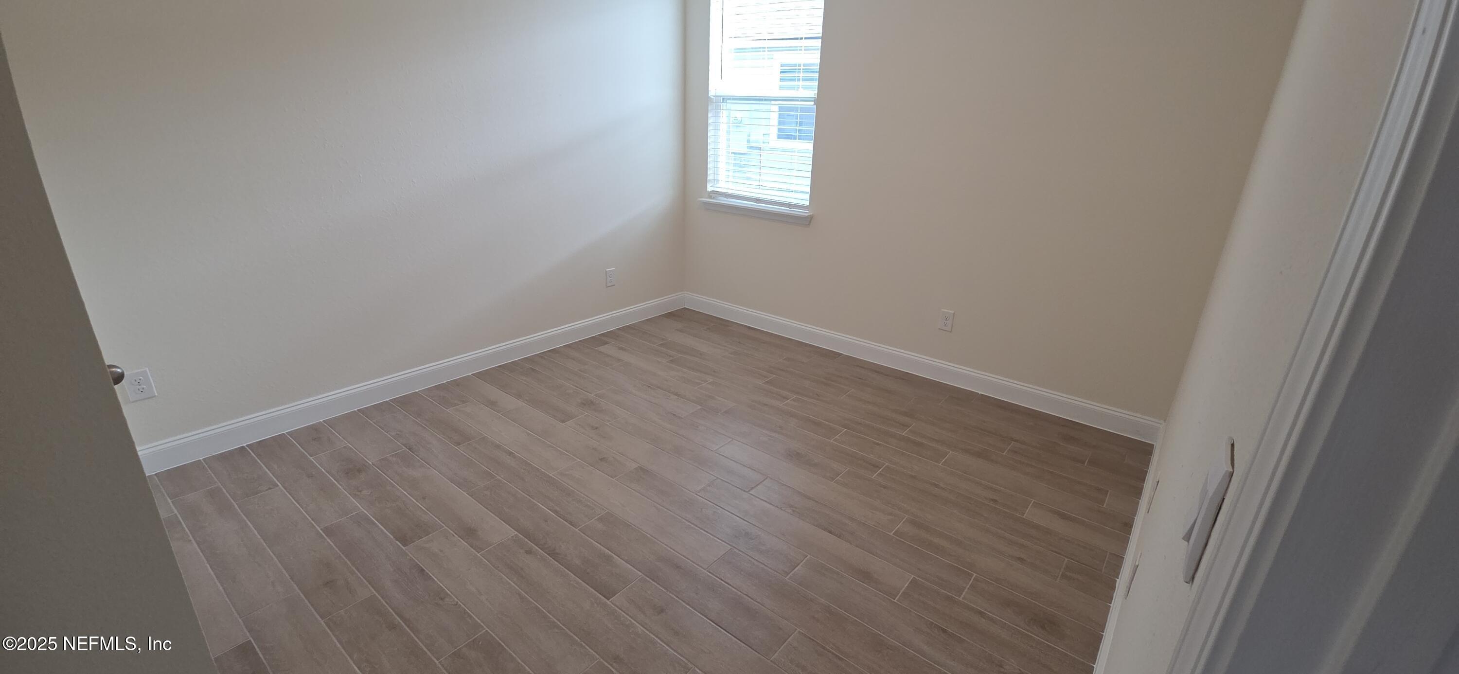 228 Thistleton Way Street St. Augustine, FL 32092 - Photo 8 of 25 a view of a small space with wooden floor and a window