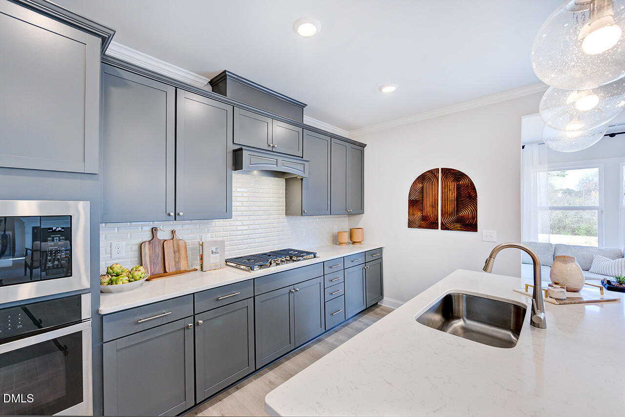 1112 Sun Spgs Road Wake Forest, NC 27587 - Photo 12 of 44 a kitchen with stainless steel appliances a sink a stove a refrigerator cabinets and a counter top space