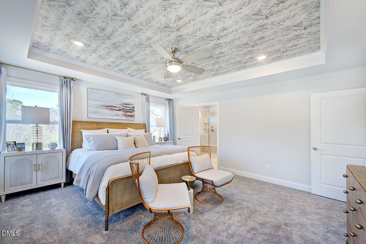 1112 Sun Spgs Road Wake Forest, NC 27587 - Photo 23 of 44 a spacious bedroom with a bed a table and chair