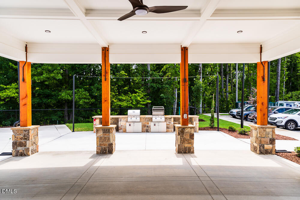 1112 Sun Spgs Road Wake Forest, NC 27587 - Photo 39 of 44 a view of a patio with a table chairs and a floor to ceiling window