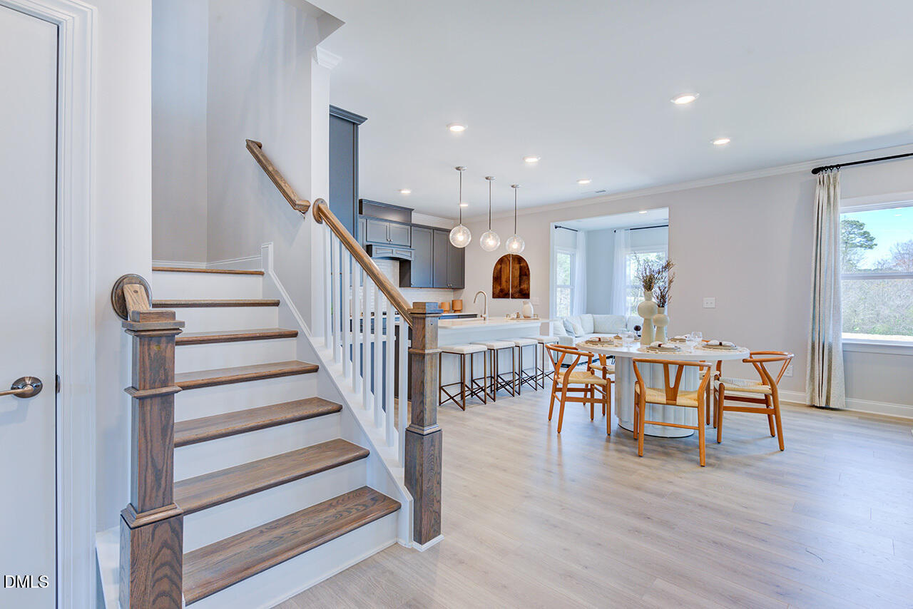 1112 Sun Spgs Road Wake Forest, NC 27587 - Photo 8 of 44 a view of a dining room with furniture wooden floor and staircase
