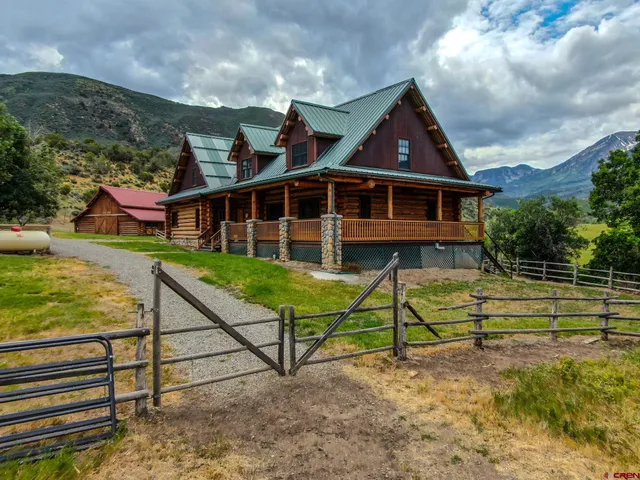 a view of a house with wooden deck and a big yard