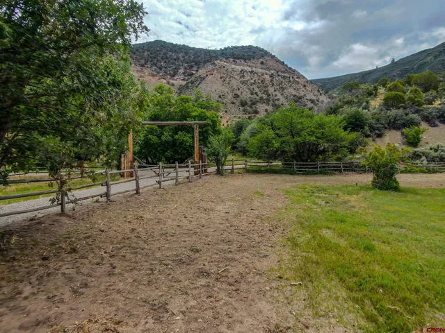 a backyard of a house with lots of green space and fountain