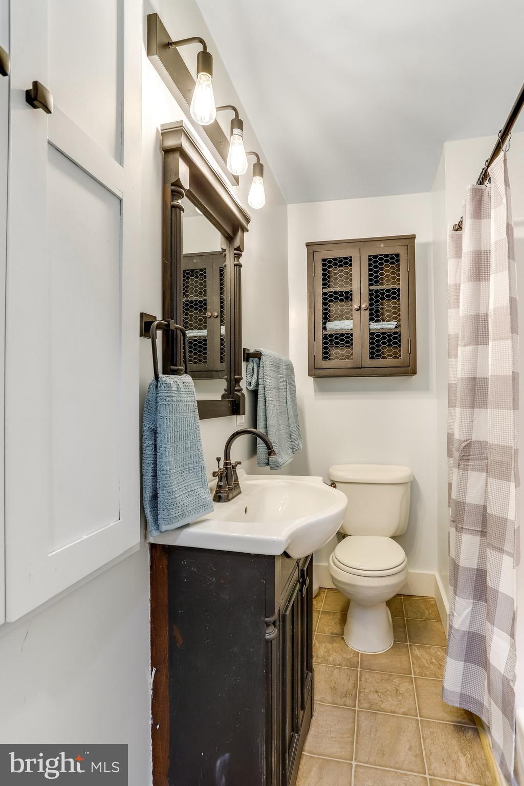 6343 Yeagertown Road New Market, MD 21774 - Photo 28 of 58 a bathroom with a sink toilet a mirror and shower