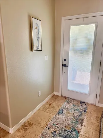 a kitchen with stainless steel appliances kitchen island granite countertop a table chairs and a refrigerator