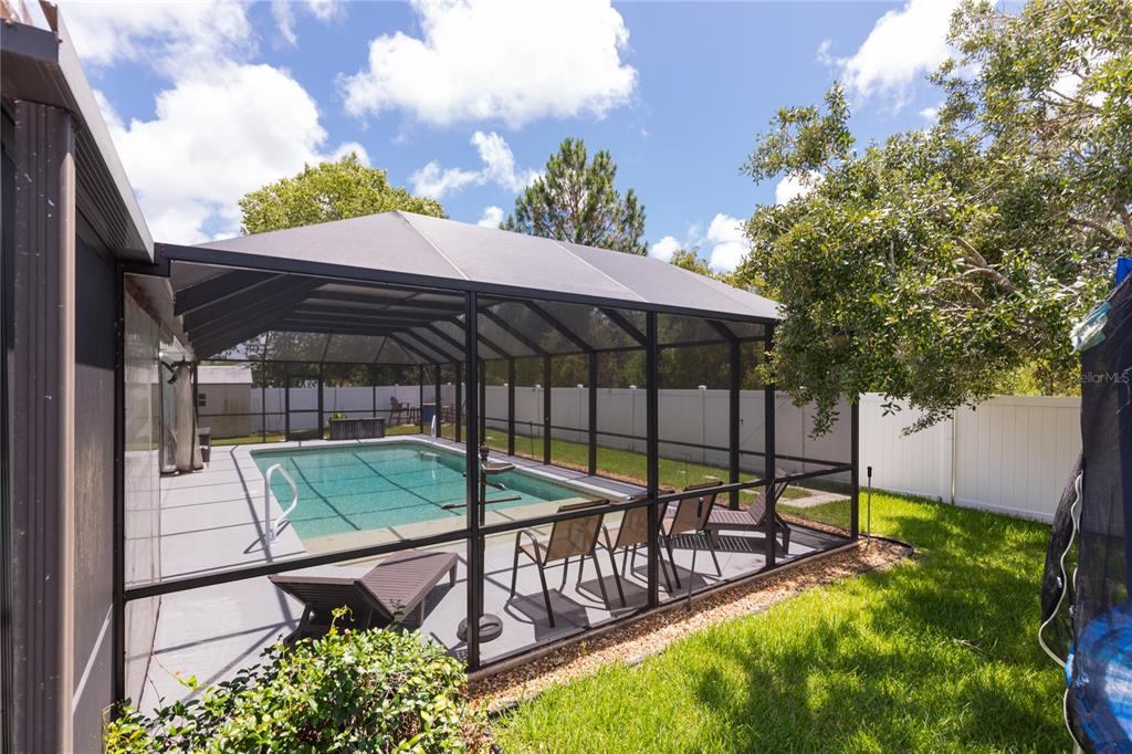 7 Lancaster Lane Palm Coast, FL 32137 - Photo 49 of 67 a view of a patio with a table and chairs under an umbrella with a small garden