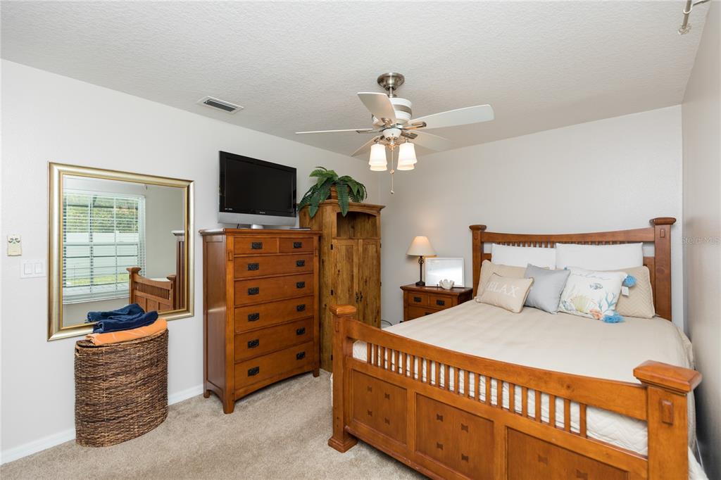 7 Lancaster Lane Palm Coast, FL 32137 - Photo 65 of 67 a bedroom with a bed and a flat tv screen on dresser