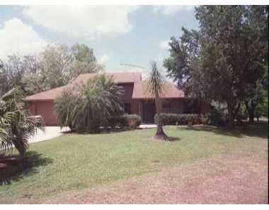 7003 Southwest Victoria Court Stuart, FL 34997 - Photo 1 of 1 a backyard of a house with lots of green space