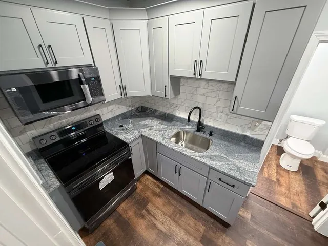 a kitchen with appliances a sink and cabinets
