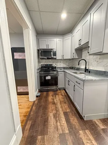 a large kitchen with stainless steel appliances granite countertop a stove a sink dishwasher and a refrigerator