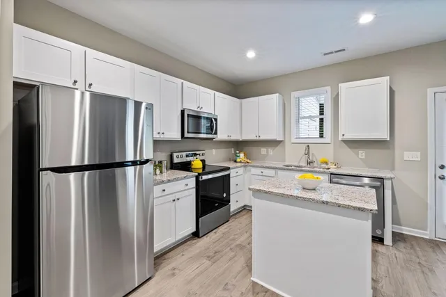 a kitchen with a refrigerator a stove a microwave a sink and cabinets