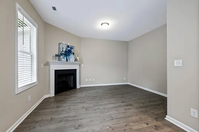 a view of an empty room with a window and fireplace