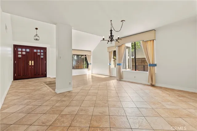 a view of a hallway with wooden floor and chandelier