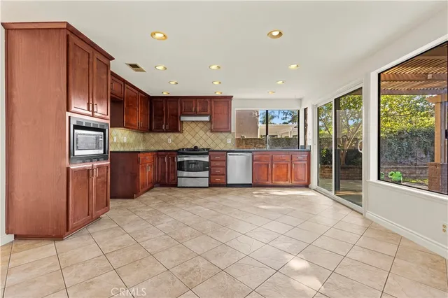 a view of kitchen with stainless steel appliances granite countertop a refrigerator and a sink