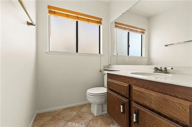 a view of an empty room with wooden floor and a bathroom