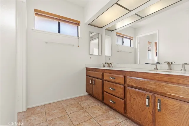 an empty room with wooden floor closet and windows