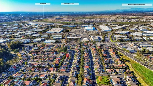 an aerial view of residential houses with outdoor space and parking