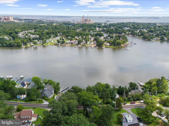an aerial view of city and lake with trees in back