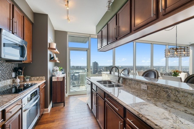 1629 South Prairie Avenue, Unit 2906 Chicago, IL 60616 - Photo 7 of 21 a kitchen with stainless steel appliances granite countertop a sink a stove and cabinets