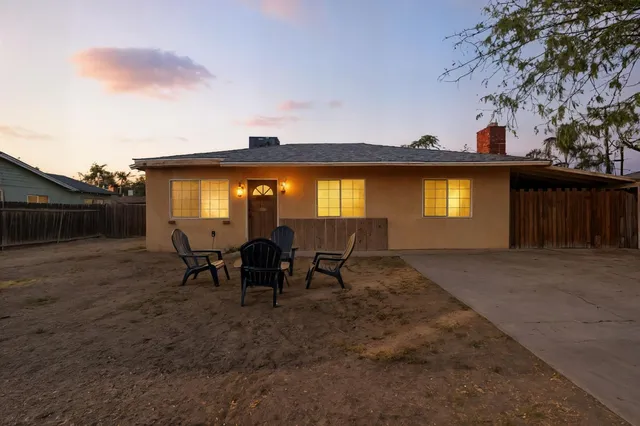 a view of a house with backyard and sitting area