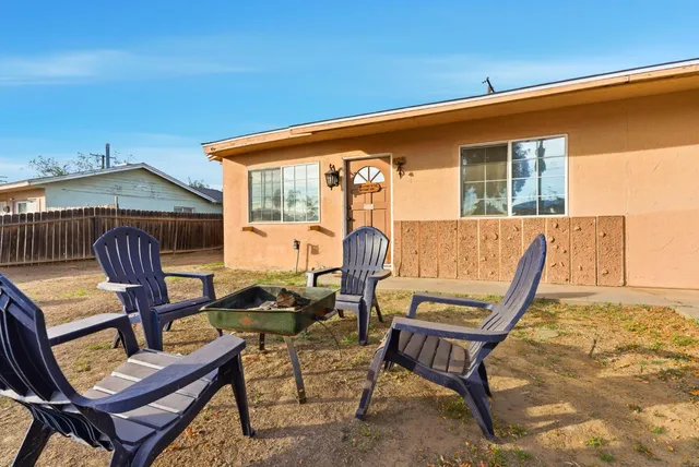 a backyard of a house with barbeque oven table and chairs