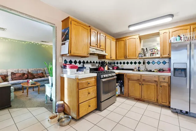 a kitchen with stainless steel appliances granite countertop a stove a sink and a refrigerator