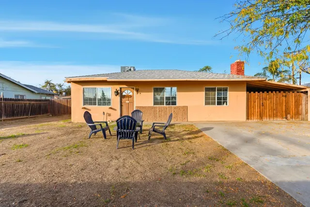 a view of a house with backyard and a sitting area