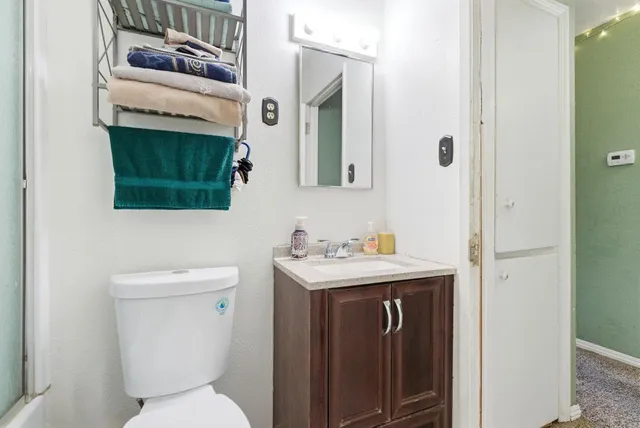 a bathroom with a toilet sink and mirror