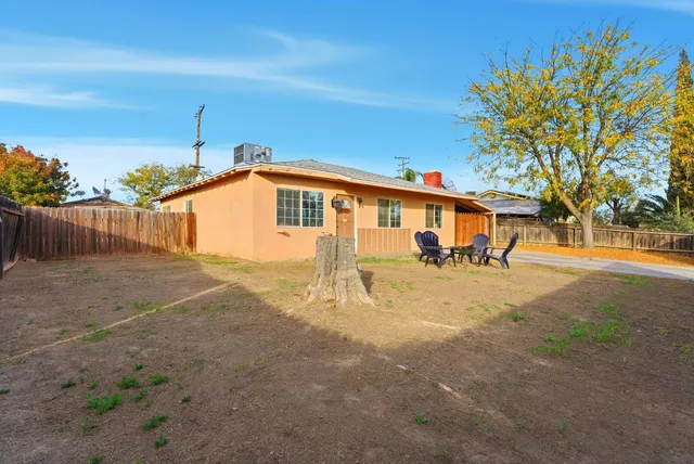 a view of house with backyard and trees