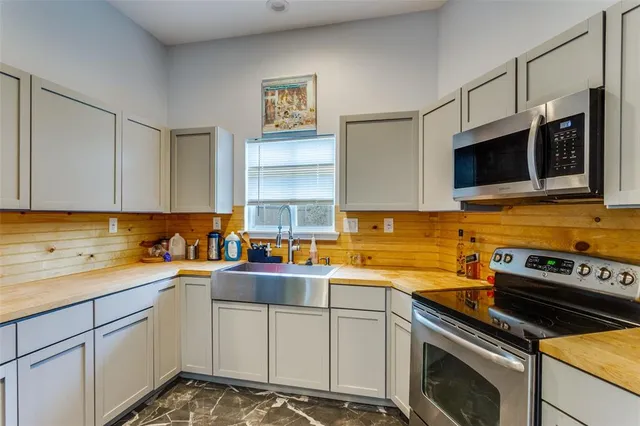 a kitchen with stainless steel appliances a stove sink microwave and cabinets