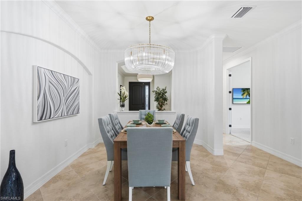 9479 Piacere Way Naples, FL 34113 - Photo 11 of 48 Recessed archway with crown molding, contemporary chandelier, and tile flooring
